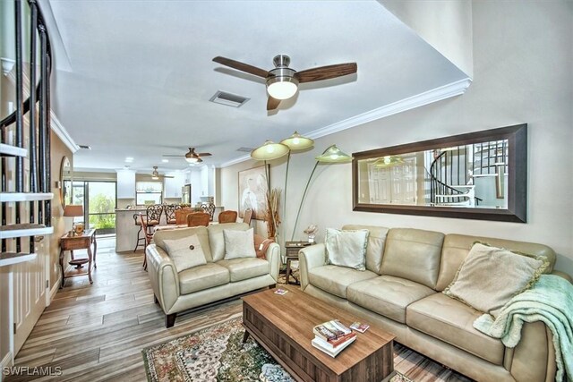 4803 SW Santa Barbara Ct Unit 2, Cape Coral, FL 33914 - living area with wood finished floors, a ceiling fan, visible vents, and ornamental molding