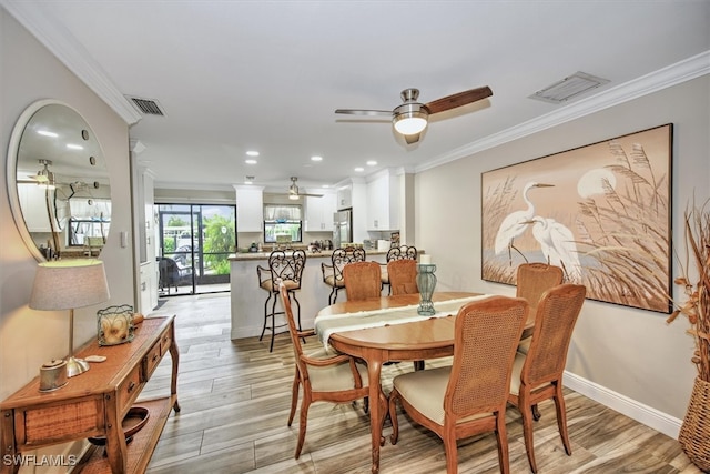 dining space featuring ceiling fan, ornamental molding, and light wood-type flooring