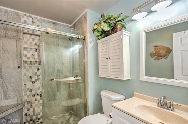 bathroom featuring a shower with door, vanity, and toilet