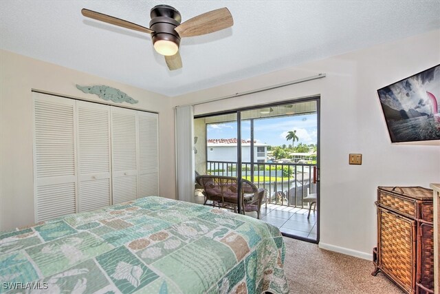 bedroom featuring a textured ceiling, a closet, access to exterior, light colored carpet, and ceiling fan