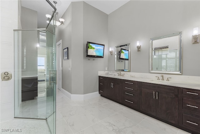 bathroom featuring vanity, a shower with shower door, a high ceiling, and an inviting chandelier