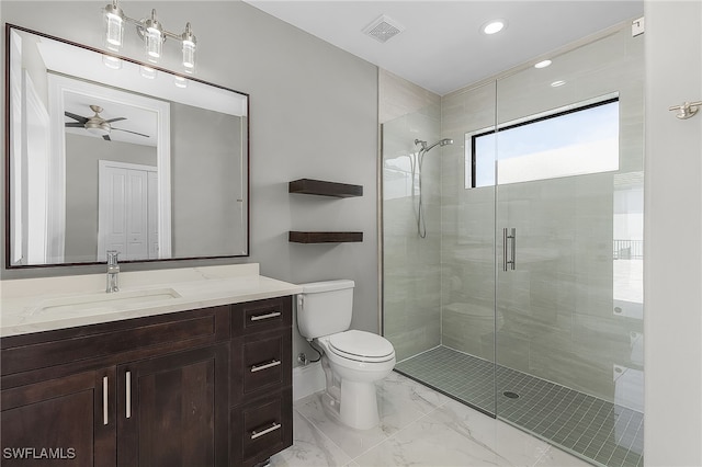 bathroom with ceiling fan, vanity, a shower with shower door, and toilet