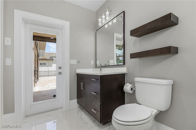 bathroom featuring marble finish floor, vanity, toilet, and baseboards