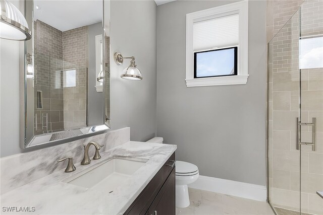 bathroom featuring vanity, toilet, and a shower with shower door