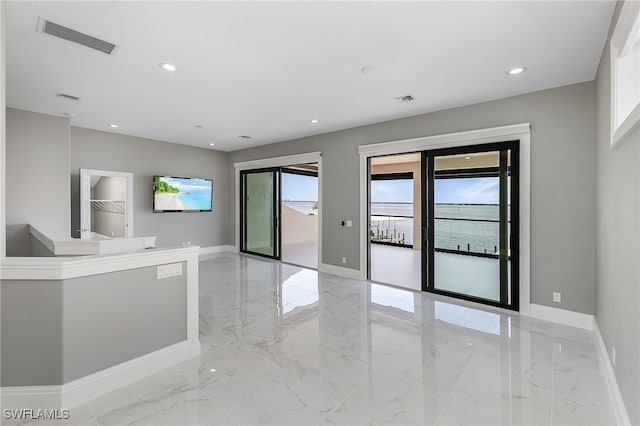 spare room with marble finish floor, baseboards, visible vents, and recessed lighting