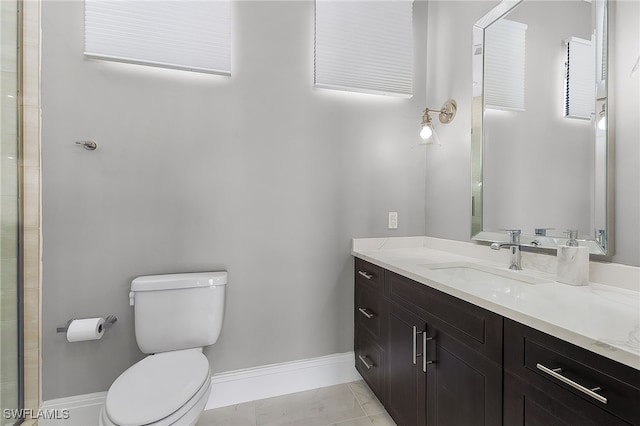 bathroom with tile patterned flooring, vanity, and toilet