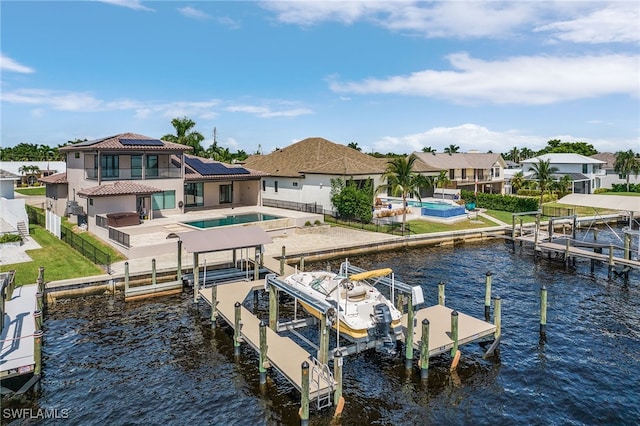 dock area featuring a swimming pool with hot tub, a water view, and a patio area