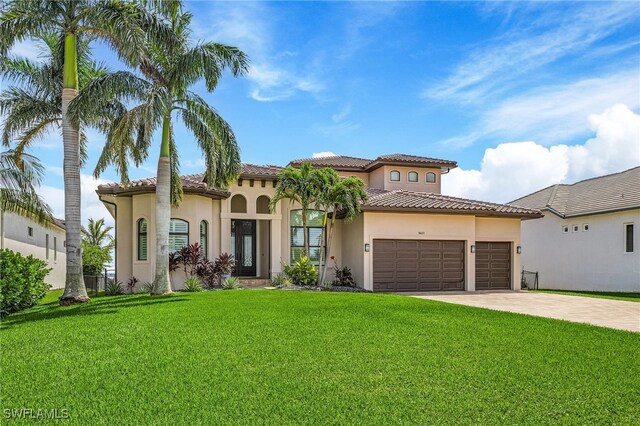 mediterranean / spanish house with a garage and a front yard