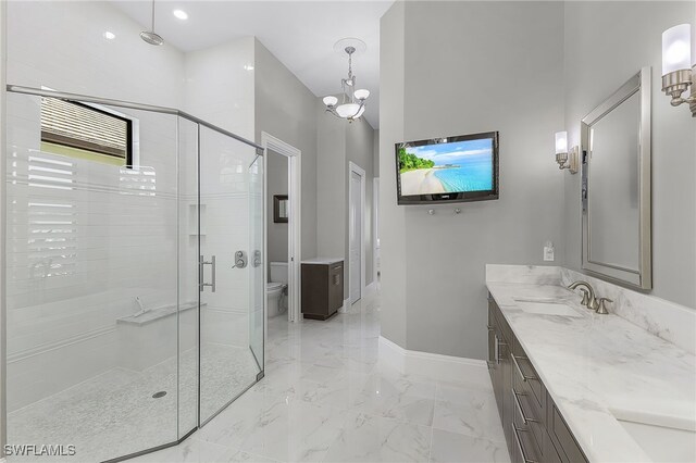 bathroom with a chandelier, vanity, toilet, and an enclosed shower