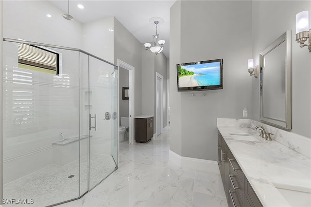 bathroom with double vanity, marble finish floor, a shower stall, and a sink