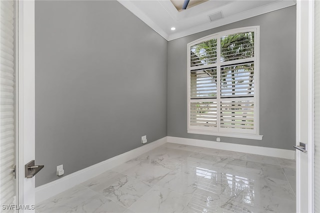 spare room with crown molding, marble finish floor, and baseboards