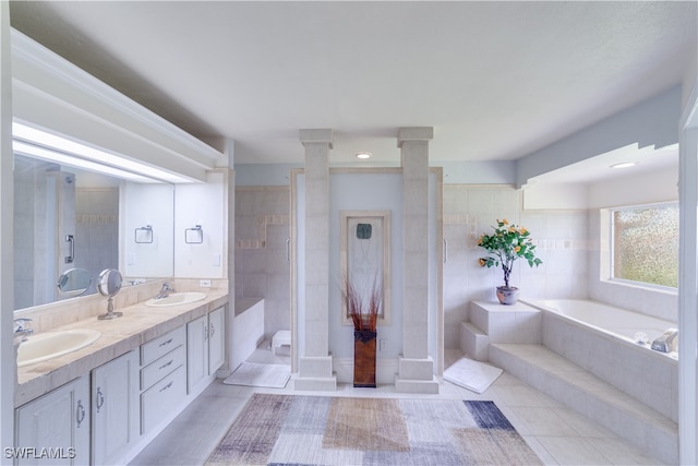 bathroom with ornate columns, vanity, plus walk in shower, and tile patterned floors