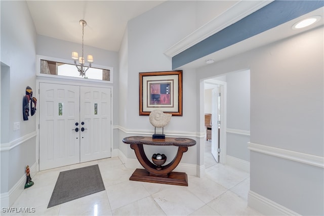 tiled foyer entrance featuring a chandelier