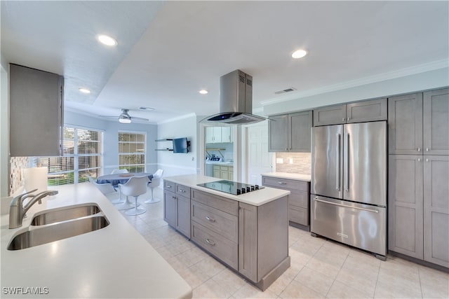 kitchen featuring island exhaust hood, built in fridge, ceiling fan, black electric stovetop, and sink