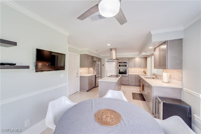 dining space featuring light tile patterned flooring, ornamental molding, sink, and ceiling fan