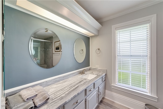 bathroom featuring ornamental molding, a shower with shower door, hardwood / wood-style flooring, and vanity