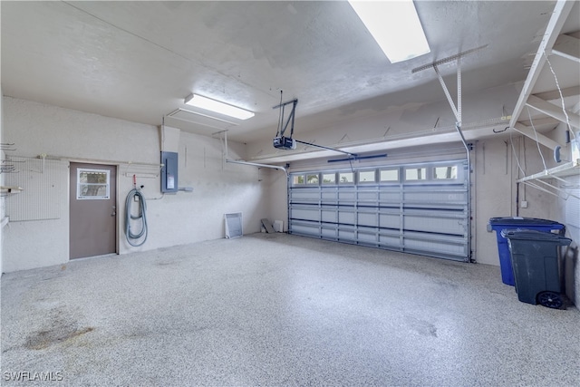 garage with a garage door opener and electric panel