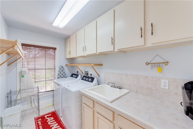 laundry area featuring cabinets, sink, and washing machine and clothes dryer