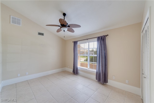 unfurnished bedroom featuring a closet, vaulted ceiling, ceiling fan, and light tile patterned floors