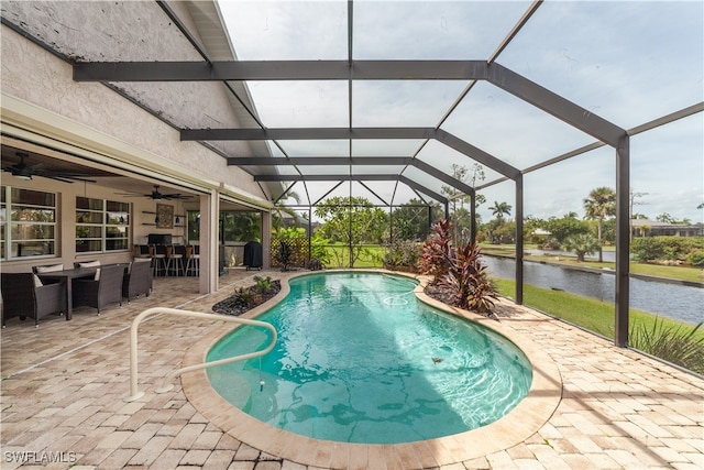 view of swimming pool featuring a lanai, a water view, ceiling fan, and a patio area