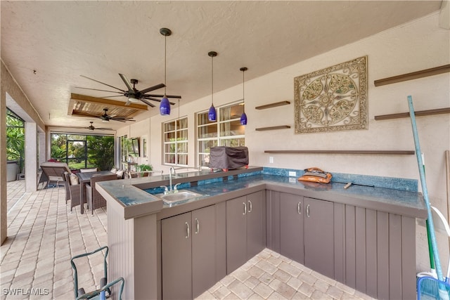 kitchen with gray cabinets, sink, kitchen peninsula, decorative light fixtures, and ceiling fan