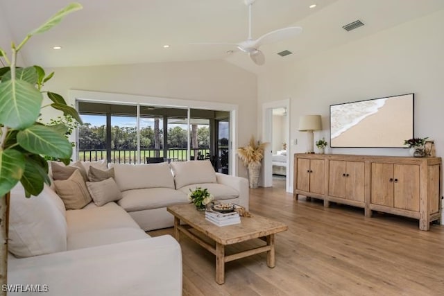 living area with ceiling fan, vaulted ceiling, visible vents, and light wood-type flooring