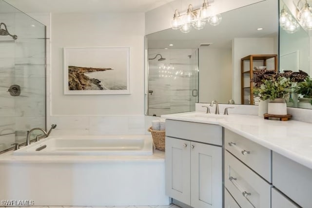 bathroom featuring a garden tub, an inviting chandelier, a stall shower, and vanity