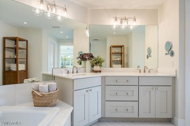 full bath featuring a sink, double vanity, and a washtub