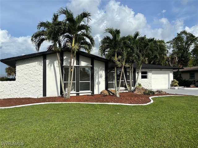 view of front of house featuring a front yard, a garage, and a sunroom