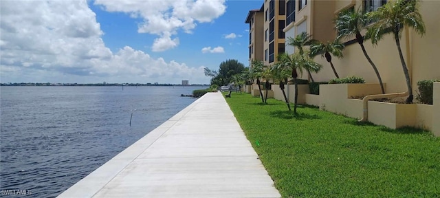 dock area with a yard and a water view