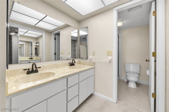 bathroom with tile patterned flooring, vanity, and toilet