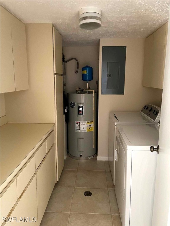 laundry area featuring cabinet space, light tile patterned floors, electric panel, washing machine and clothes dryer, and water heater