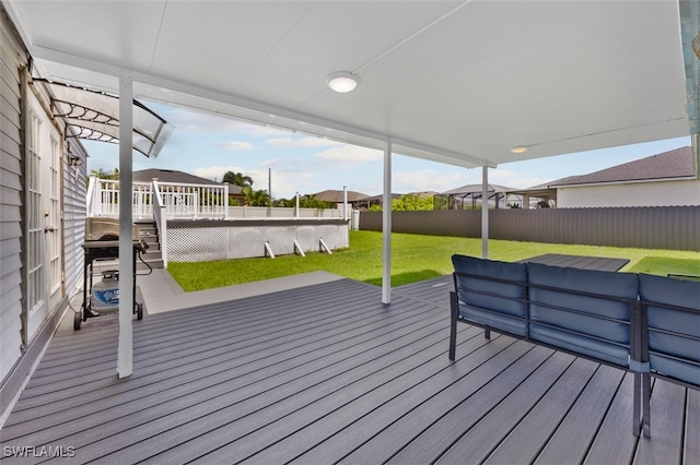 wooden terrace featuring a yard and area for grilling