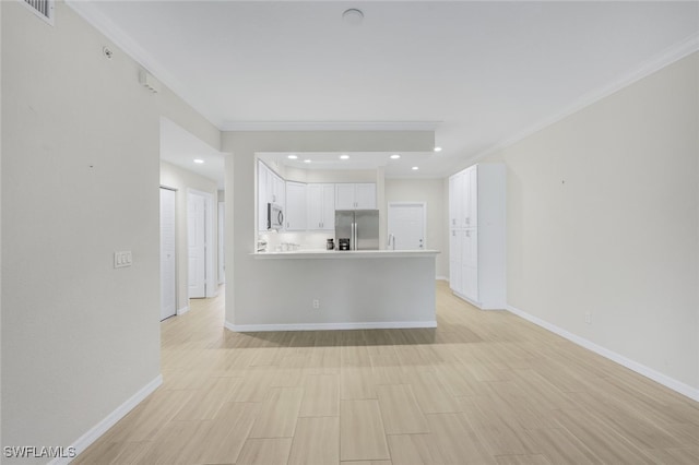 kitchen featuring kitchen peninsula, stainless steel appliances, ornamental molding, white cabinetry, and light wood-type flooring