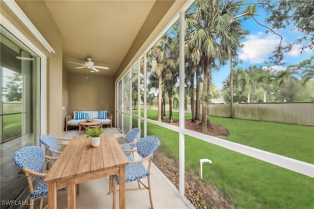 sunroom / solarium featuring ceiling fan