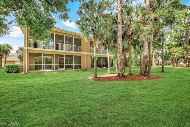 back of property featuring a lawn and a balcony