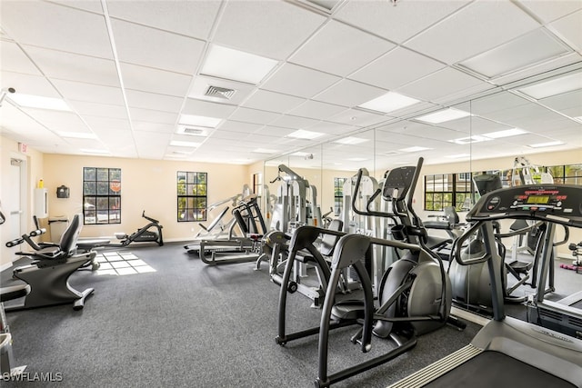 exercise room with a wealth of natural light and a drop ceiling