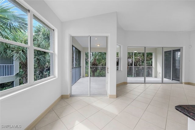 spare room with light tile patterned floors and vaulted ceiling