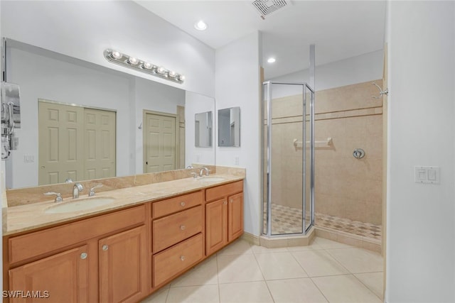 bathroom featuring tile patterned flooring, vanity, and a shower with shower door