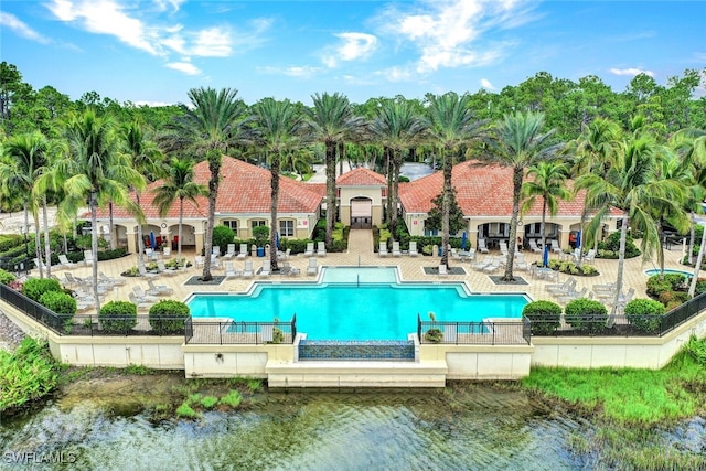 view of pool with a patio area and a water view