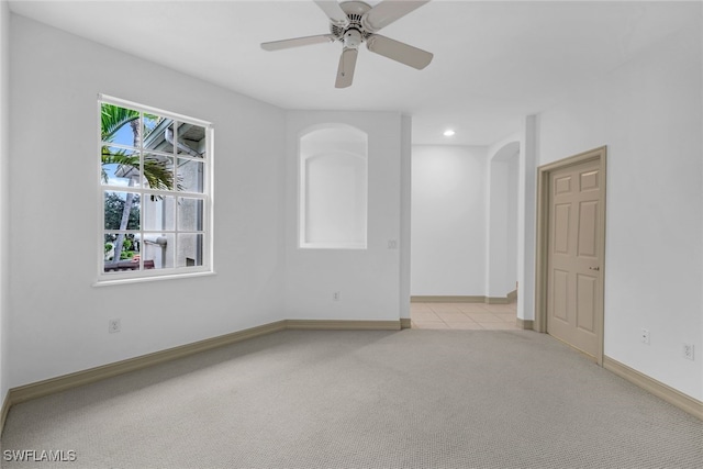 carpeted spare room featuring ceiling fan