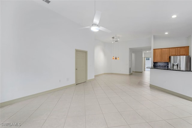 unfurnished living room featuring light tile patterned floors, vaulted ceiling, and ceiling fan