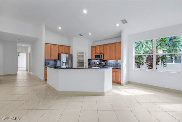 kitchen featuring decorative backsplash, a kitchen island, vaulted ceiling, and appliances with stainless steel finishes