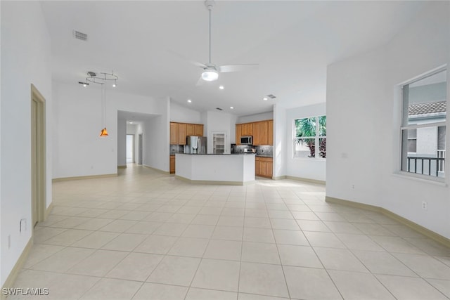 kitchen with ceiling fan, light tile patterned flooring, appliances with stainless steel finishes, and vaulted ceiling