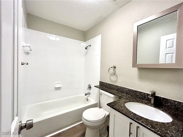 full bathroom featuring vanity, tiled shower / bath combo, a textured ceiling, hardwood / wood-style flooring, and toilet