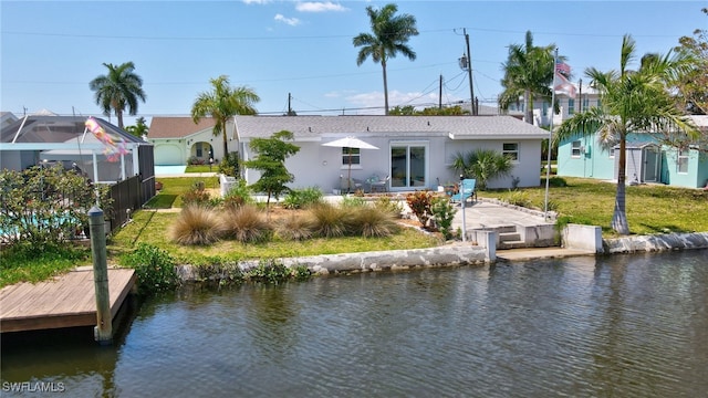 back of property featuring a patio, a yard, and a water view