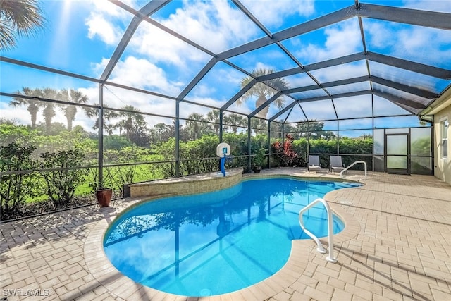 view of swimming pool featuring a lanai and a patio