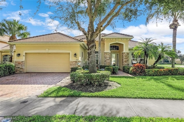 mediterranean / spanish-style house featuring a garage and a front lawn