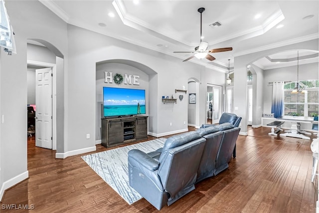 living room with a tray ceiling, crown molding, ceiling fan, and dark hardwood / wood-style floors