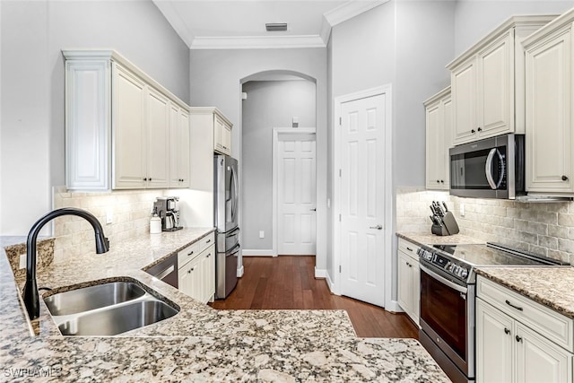 kitchen featuring dark hardwood / wood-style floors, backsplash, stainless steel appliances, ornamental molding, and sink